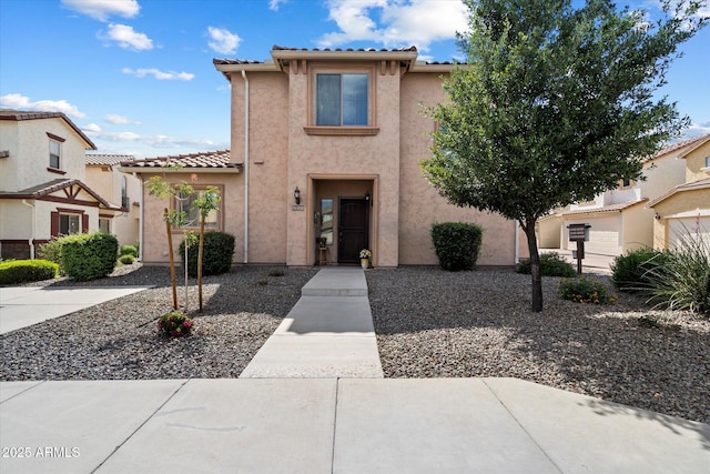 view of front of house with stucco siding and a tile roof
