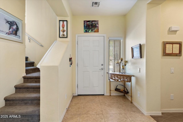entrance foyer with light tile patterned floors, baseboards, stairs, and visible vents