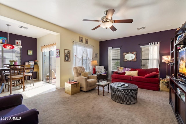 living area with plenty of natural light, ceiling fan, and visible vents