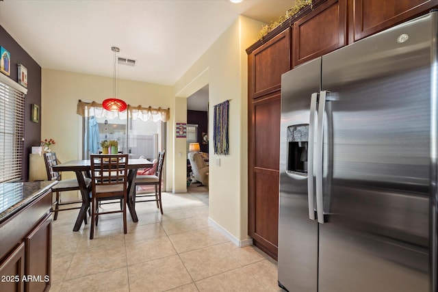 dining space featuring light tile patterned floors and baseboards