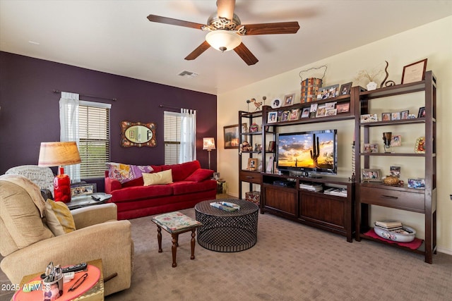 living room with ceiling fan, light colored carpet, and visible vents