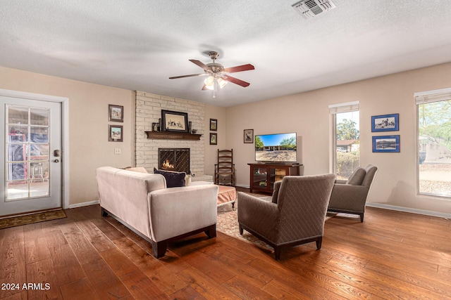 12423 N 64th St, Scottsdale, AZ 85254 - living area with hardwood / wood-style floors, a brick fireplace, a ceiling fan, and baseboards