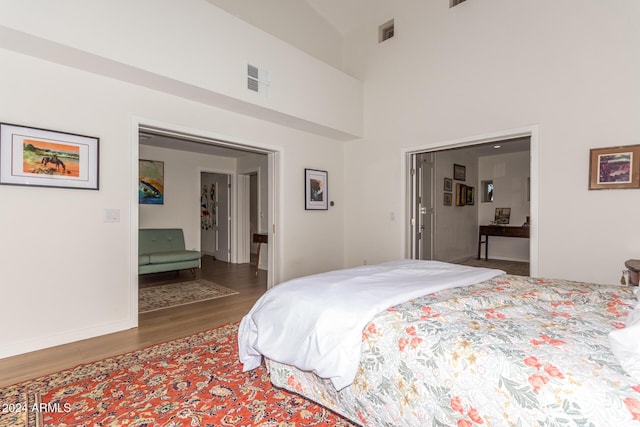12423 N 64th St, Scottsdale, AZ 85254 - bedroom featuring wood finished floors, ensuite bath, baseboards, and a towering ceiling
