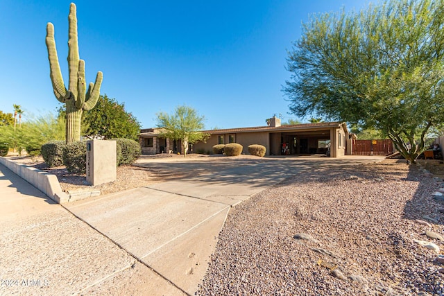 12423 N 64th St, Scottsdale, AZ 85254 - ranch-style home with driveway, a chimney, stucco siding, and a carport
