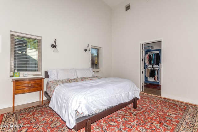 12423 N 64th St, Scottsdale, AZ 85254 - bedroom featuring high vaulted ceiling, wood finished floors, a spacious closet, and baseboards