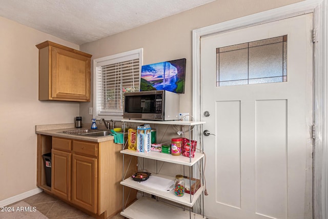 12423 N 64th St, Scottsdale, AZ 85254 - kitchen with stainless steel microwave, a sink, light tile patterned floors, light countertops, and baseboards