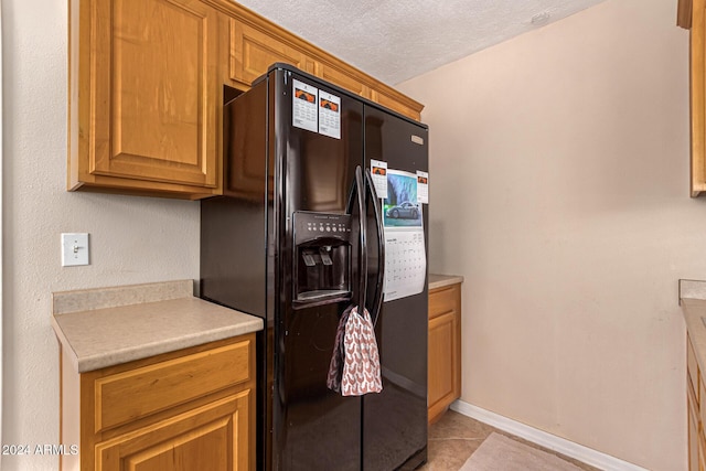 12423 N 64th St, Scottsdale, AZ 85254 - kitchen featuring black fridge, light tile patterned floors, light countertops, a textured ceiling, and baseboards