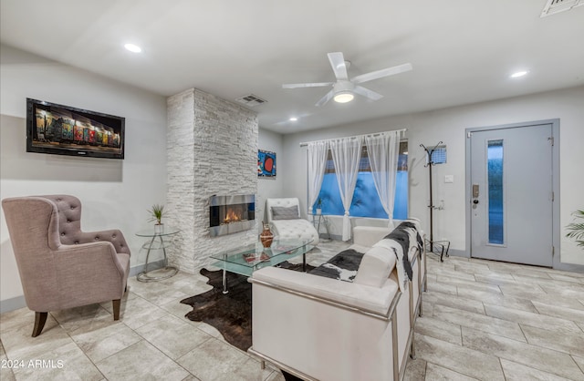 living room with a fireplace and ceiling fan