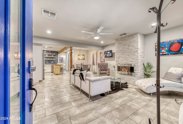 living room featuring a fireplace and ceiling fan