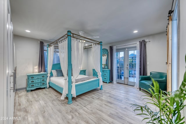 bedroom with french doors, a barn door, access to exterior, and light hardwood / wood-style floors