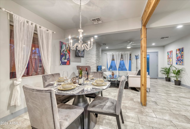 dining space featuring ceiling fan with notable chandelier