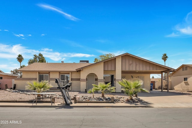 view of front of home featuring an attached carport, driveway, and stucco siding