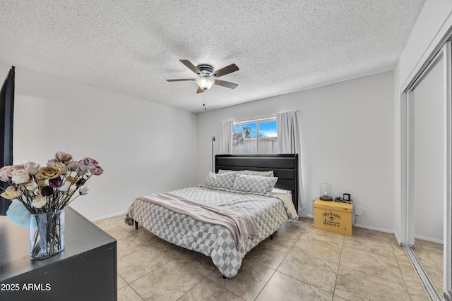 bedroom with a closet, baseboards, a textured ceiling, and a ceiling fan