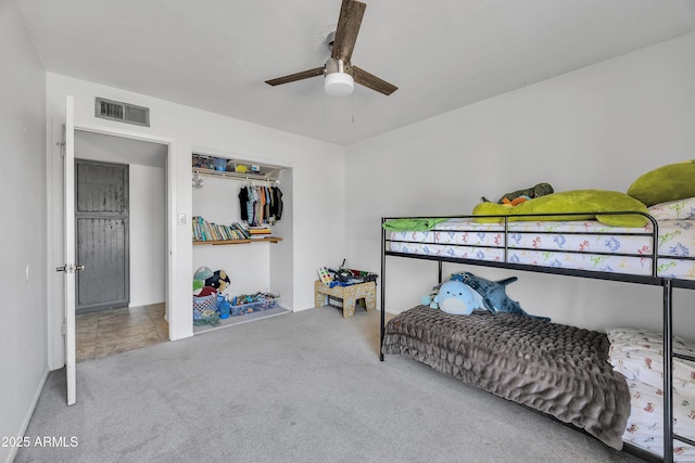 carpeted bedroom featuring visible vents, a closet, and ceiling fan