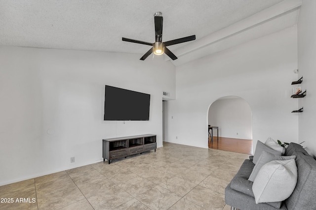 living room with high vaulted ceiling, arched walkways, a textured ceiling, and a ceiling fan