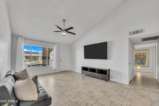 living area with light tile patterned floors, a ceiling fan, visible vents, and a textured ceiling