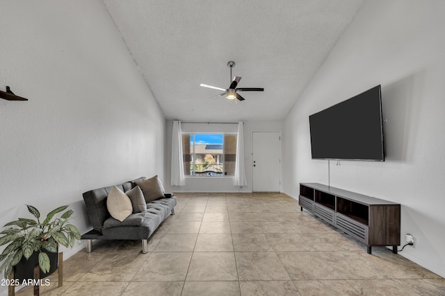 living room with a textured ceiling, ceiling fan, light tile patterned flooring, and vaulted ceiling