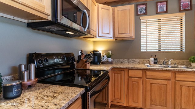 kitchen with black / electric stove, light brown cabinetry, and sink