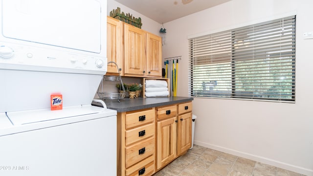 washroom featuring cabinets and stacked washer and dryer