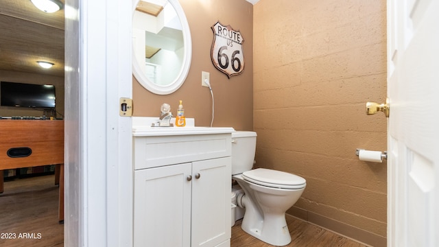 bathroom with vanity, toilet, and wood-type flooring