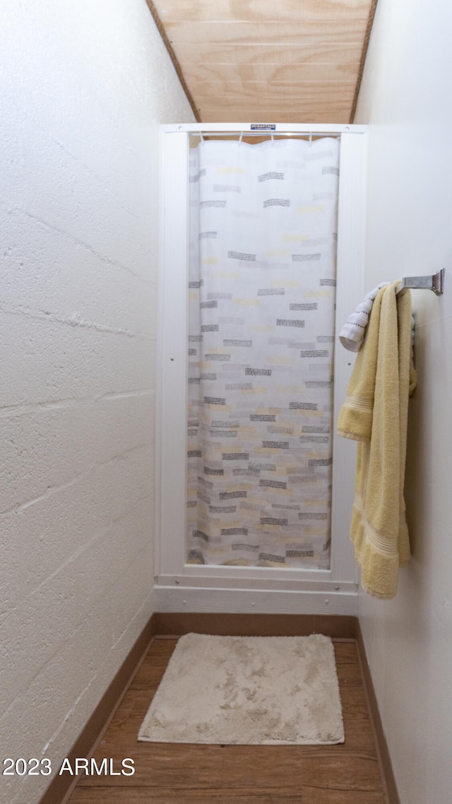 bathroom featuring walk in shower, wooden ceiling, and wood-type flooring