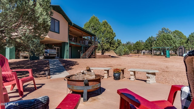 view of patio / terrace featuring a shed and a fire pit