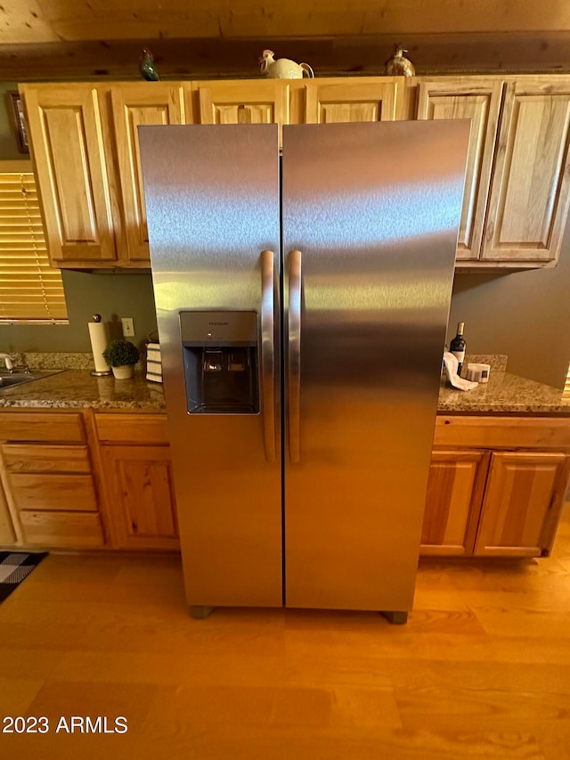 kitchen with light hardwood / wood-style floors and stainless steel fridge with ice dispenser