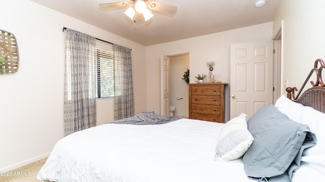 bedroom with connected bathroom, light colored carpet, and ceiling fan