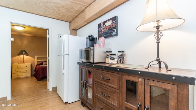 interior space featuring light hardwood / wood-style flooring, dark brown cabinets, and white refrigerator