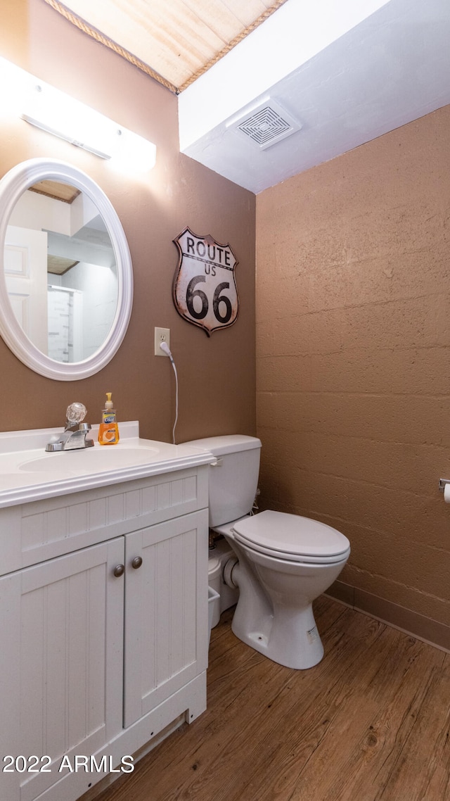 bathroom featuring vanity, hardwood / wood-style floors, and toilet