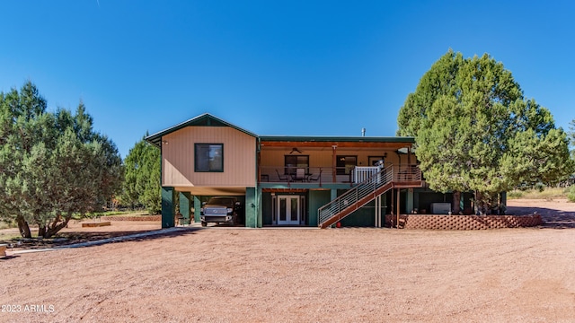 rear view of property featuring a carport and ceiling fan