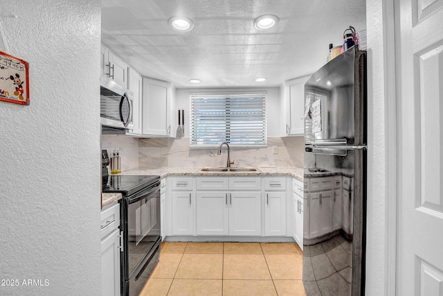 3027 E Grandview Rd Unit 1, Phoenix, AZ 85032 - kitchen with black appliances, white cabinetry, a textured wall, light tile patterned floors, and recessed lighting
