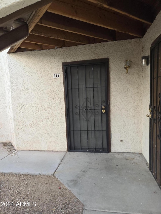 doorway to property featuring stucco siding