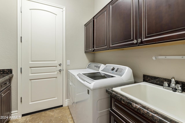 laundry room featuring cabinets, sink, and washing machine and clothes dryer