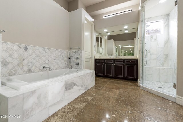 bathroom with vanity, tile walls, and independent shower and bath