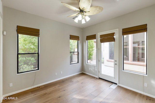 empty room with ceiling fan and light hardwood / wood-style flooring