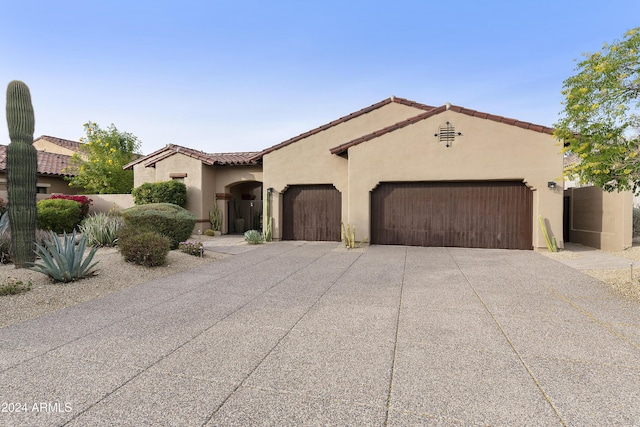 mediterranean / spanish home featuring a garage