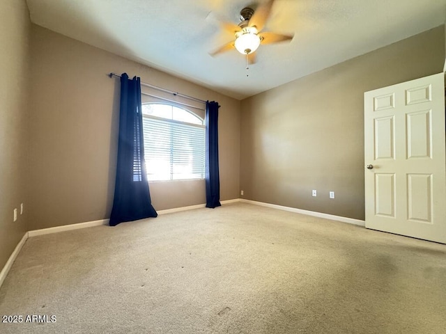 unfurnished room with baseboards, ceiling fan, and light carpet
