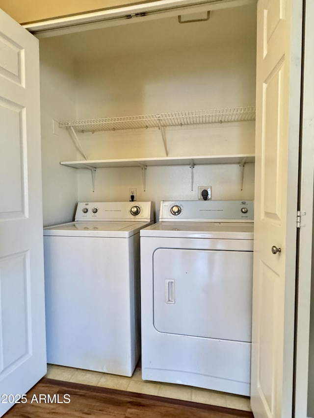 laundry area with independent washer and dryer, laundry area, and light wood-style floors