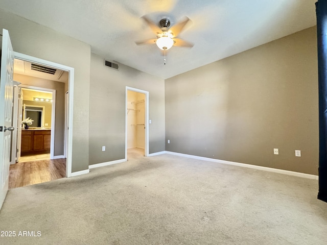unfurnished bedroom featuring carpet floors, baseboards, a spacious closet, and visible vents