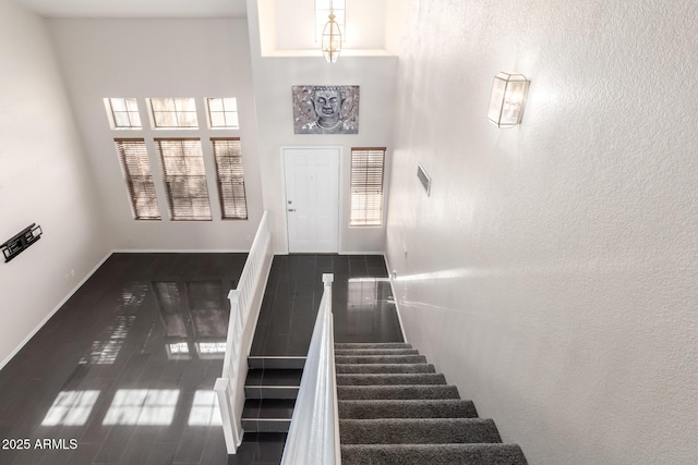 stairway featuring a towering ceiling and hardwood / wood-style floors