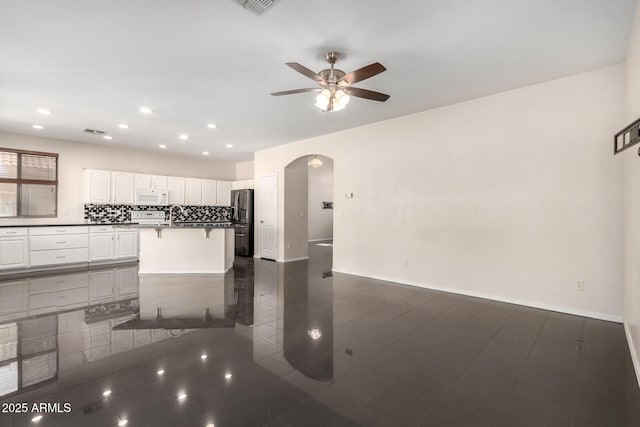 kitchen with sink, white appliances, ceiling fan, white cabinetry, and backsplash