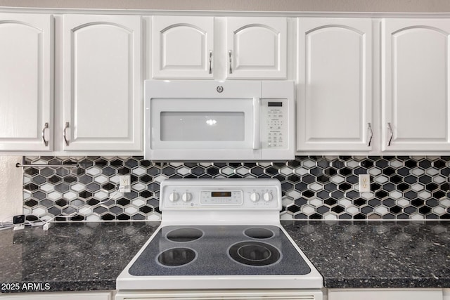 kitchen featuring tasteful backsplash, white appliances, dark stone countertops, and white cabinets