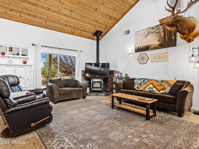 living room with wooden ceiling, tile patterned flooring, a wood stove, and high vaulted ceiling