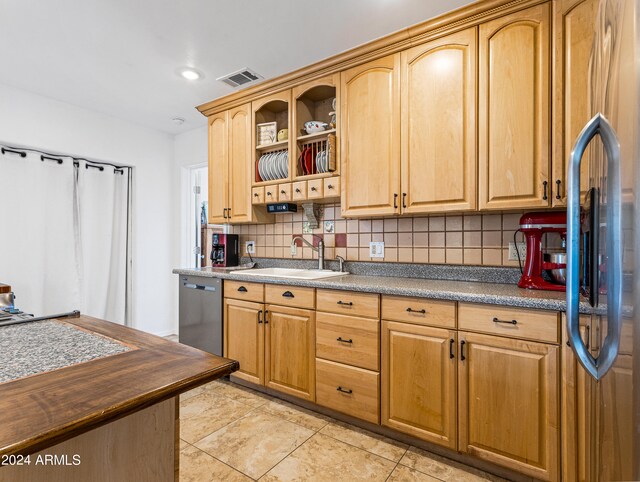 kitchen with backsplash, dishwasher, light tile patterned flooring, and sink