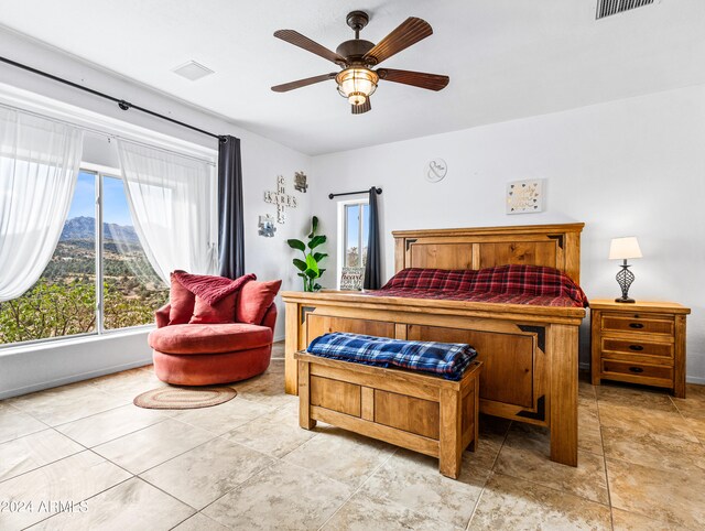 bedroom featuring a mountain view and ceiling fan