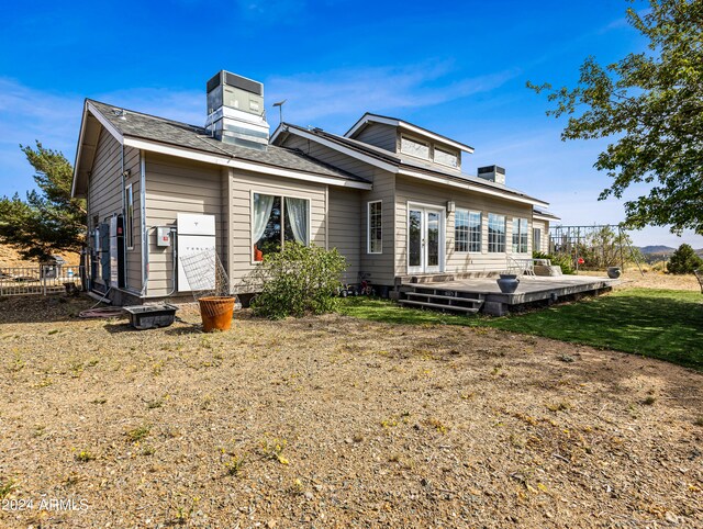 back of house featuring a wooden deck and a lawn