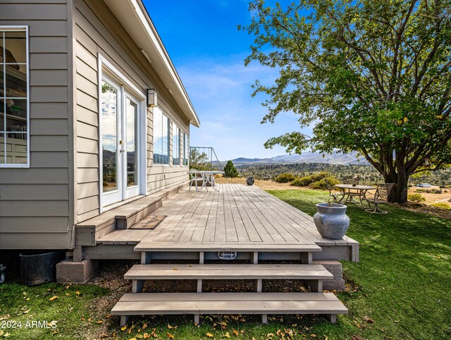 wooden terrace with a lawn and a mountain view