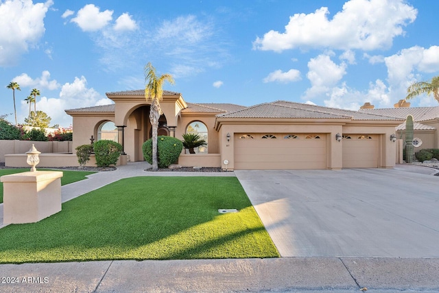 mediterranean / spanish-style home with a front yard and a garage