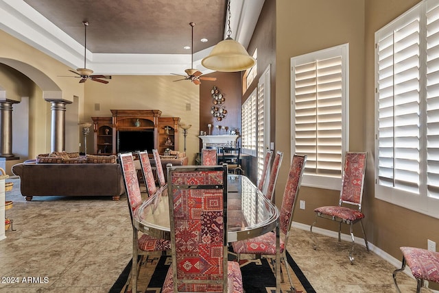 dining space with ceiling fan and ornate columns